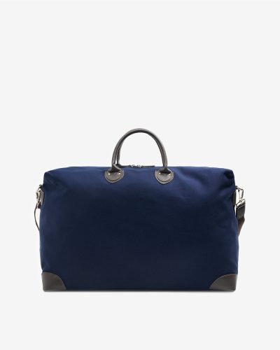 Stor reiseveske i mørkeblå bomullscanvas med detaljer i brunt skinn