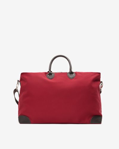 Stor reiseveske i mørkerød bomullscanvas med detaljer i brunt skinn