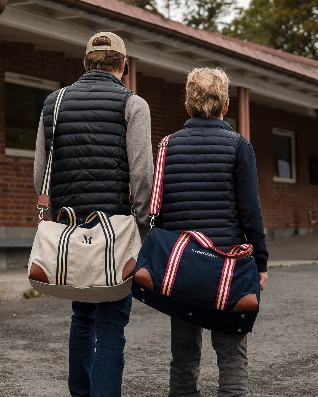 To gutter med skolevesker over skulderen. En i lys lin og en i mørk blå.