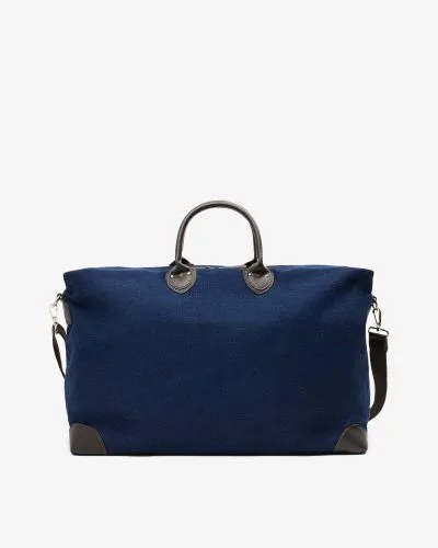 Stor reiseveske i mørkeblå denim med detaljer i brunt skinn