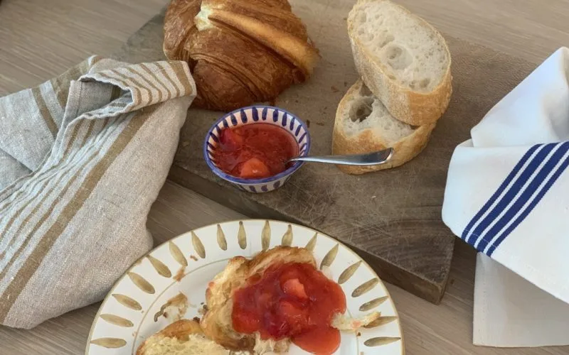 Fransk baguett og croissant med hjemmelaget jordbærsyltetøy.