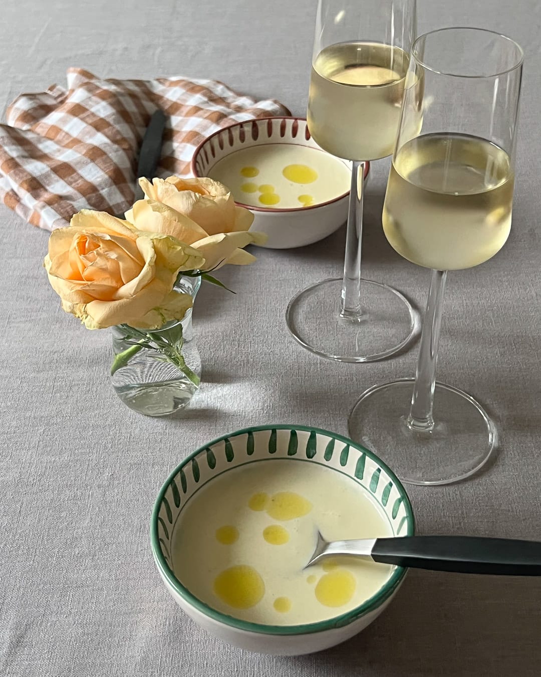 Kremet blomkålsupe med chorizo servert i rustikke boller på beige linduk.